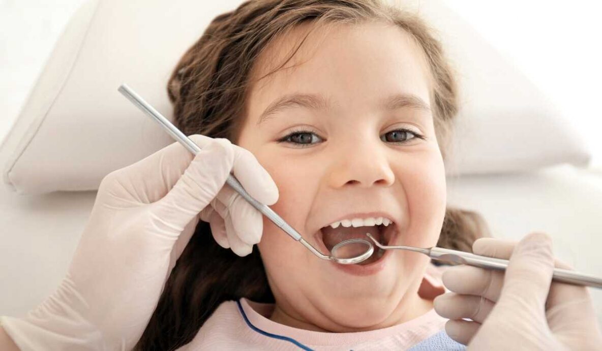 Kids dentist examining young patient at Trafalgar Village Dental
