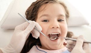 Kids dentist examining young patient at Trafalgar Village Dental