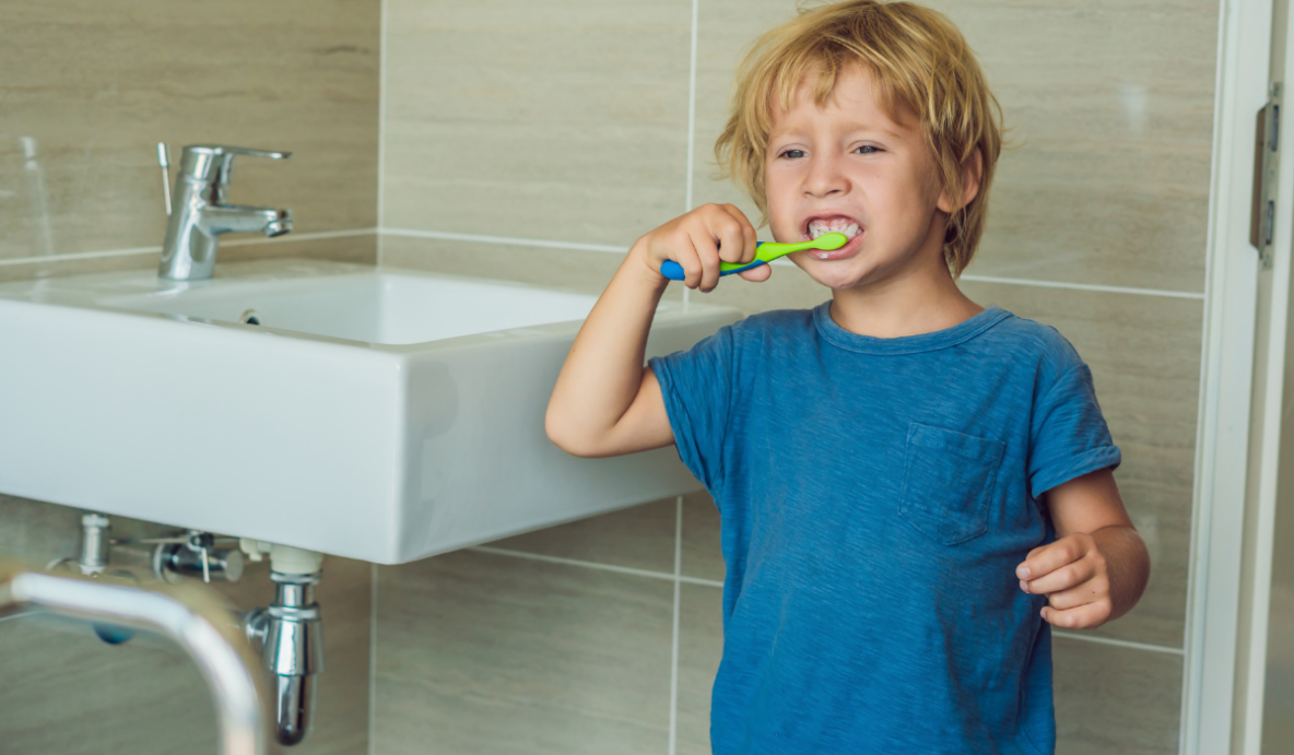 Kids dentist at Trafalgar Village Dental teaching proper brushing techniques to young patients in Oakville